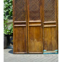 an old wooden door on the side of a brick building with latticed panels and wood flooring