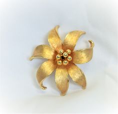 For purchase is a stylish vintage designer signed Mid Century Modern brushed gold tone metal flower pin/brooch by Kramer. Our pictures do not do justice to the workmanship of this elegant piece, which is in excellent vintage/pre-owned condition as detailed in the photos. Size: 2 3/8 inches in diameter. The center pistil is removable, could be replaced with any other push pin. This piece was acquired at an estate sale and it would make a WONDERFUL addition to any wardrobe or to your jewelry collection....OR it just might be the PERFECT gift!! Vintage Mid Century Modern, Metal Flower, Flower Pins, Metal Flowers, Vintage Designer, Metal Style, Push Pin, Flower Brooch, Pin Brooch