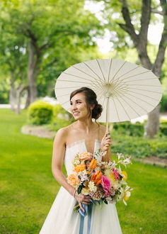 a woman in a white dress holding an umbrella