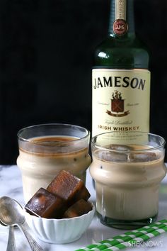 there is a bottle of jameson and two glasses with ice cream on the table next to it