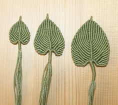 three green leaf shaped objects on a wooden surface