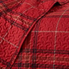 a red and black checkered quilt on a bed