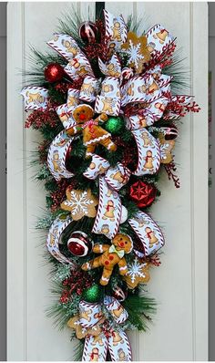 a christmas wreath with gingerbreads and candy canes hanging on the front door