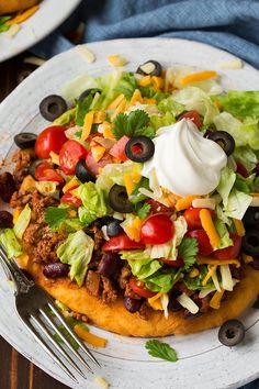 a taco salad on a plate with a fork