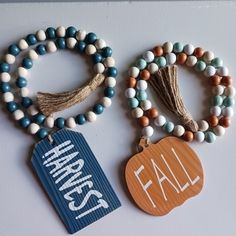 two bracelets are hanging on the wall next to each other and one has a tag that says happy fall