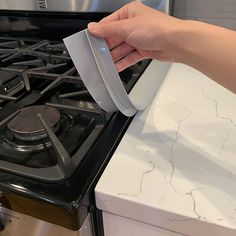 a person is opening the door to an oven with a paper towel on top of it