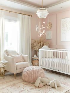 a baby's room with pink walls and white furniture