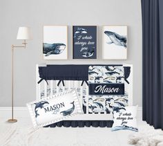 a baby crib bedding set with blue and white whale prints on the wall