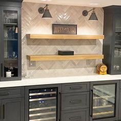 a kitchen with two wine coolers and shelves on the wall next to each other