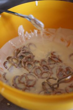 a yellow bowl filled with lots of oatmeal sitting on top of a counter