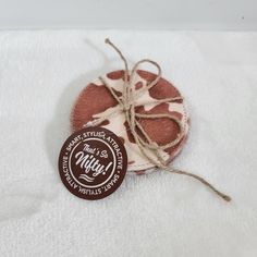 a brown and white tag sitting on top of a towel