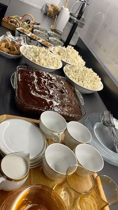 a buffet table filled with lots of food and plates on top of each other,