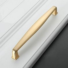 a close up of a door handle on a white and black door with gold accents