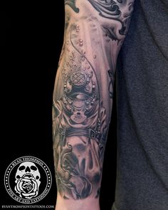 a man with a black and grey tattoo on his arm