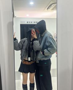 two people standing in front of a mirror