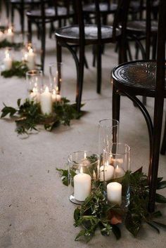 rows of chairs with candles and greenery on the floor