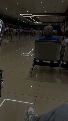 people sitting in chairs at an airport waiting for their luggage to be taken off the conveyor belt