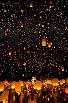 many people are flying lanterns in the night sky with lights on them and there is no image here to provide a caption for