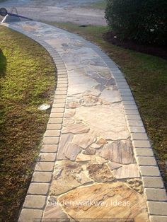 a stone path in the middle of a grassy area