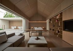 a living room with couches, tables and a television in the middle of it