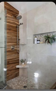 a bathroom with a glass shower door and wooden paneling on the wall behind it