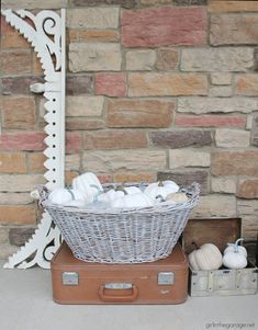 a basket filled with white balls sitting on top of a suitcase