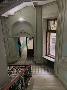 an old building with stairs and stained glass windows on the second floor, looking down