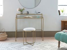 a vanity table with a mirror and stool in a living room next to a window