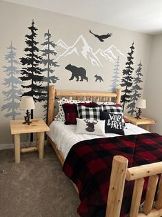 a bed room with a neatly made bed and a mountain mural on the wall behind it