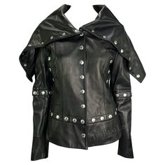 Presenting a stunning black leather Dolce and Gabbana snap jacket. From the Fall/Winter 2003 collection, many designs with these same snaps were used on the runway. This versatile jacket can be fashioned in several ways, as each snap is fully functional and allows both the sleeves and body to be shortened. A nearly identical coat was seen on Lil Kim at a 2003 Dolce and Gabbana party. Add this ultra-rare leather jacket to your collection! Approximate measurements: Size - removed Shoulder to hem: 23" Bust:36" Waist: 30" Shoulder to cuff: 26" Underarm to cuff: 19" 100% Leather Designer Leather Jacket With Rivets For Fall, Fitted Leather Jacket With Detachable Hood For Fall, Fitted Leather Biker Jacket With Detachable Hood, Gothic Leather Outerwear With Long Sleeves, Designer Winter Outerwear With Rivets, Fitted Leather Jacket With Hood And Padded Collar, Fitted Leather Jacket With Padded Collar And Hood, Fitted Hooded Leather Jacket With Padded Collar, Biker Outerwear With Snap Buttons For Winter