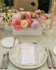 the table is set with flowers and silverware