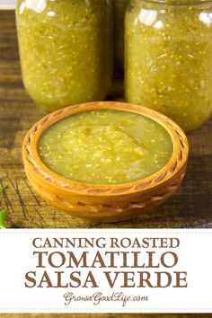 two jars filled with green salsa sitting on top of a wooden table