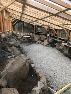 the inside of a building that has rocks and gravel in it, with two people sitting at tables