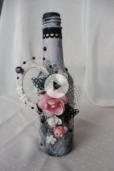 a bottle decorated with flowers and pearls