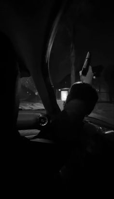 a person sitting in the passenger seat of a car at night