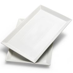 two white square plates sitting side by side on a white surface with one empty plate in the middle