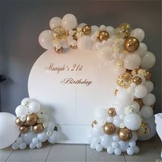 balloons and streamers decorate the backdrop for a 21st birthday party in gold and white