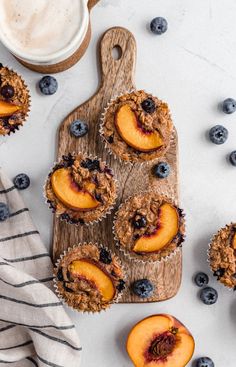 muffins with blueberries and peaches on a cutting board