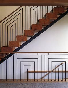 an empty room with a stair case and wooden handrails