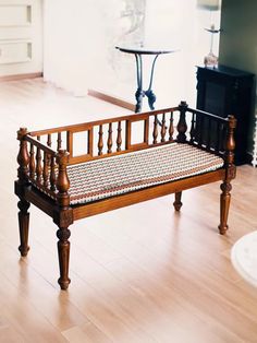 a wooden bench sitting on top of a hard wood floor