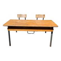 an old wooden desk with two chairs on it and one is missing the back end