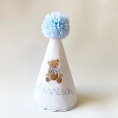 a small white party hat with a blue pom - pom on the top