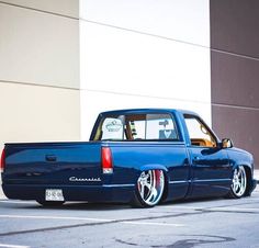 a blue pick up truck parked in front of a building