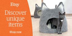 a black cat sitting in a grey kitty house with the words easy discovery unique items shop now