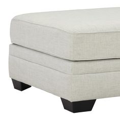 a white ottoman with black legs on a white background