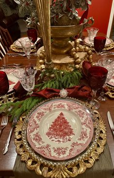 a christmas table setting with red and gold plates