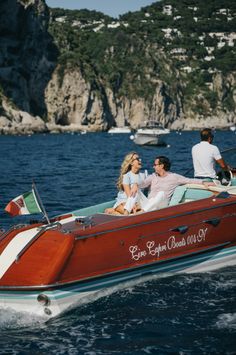 two people in a red and white boat on the water