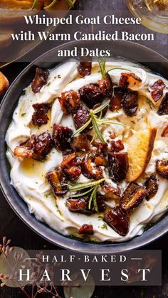 a bowl filled with cream cheese and bacon on top of bread slices next to wine glasses