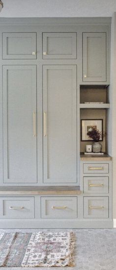 an empty room with white cabinets and rugs on the floor in front of it