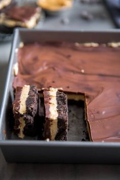 chocolate cake with white and brown frosting in a metal pan on top of a table